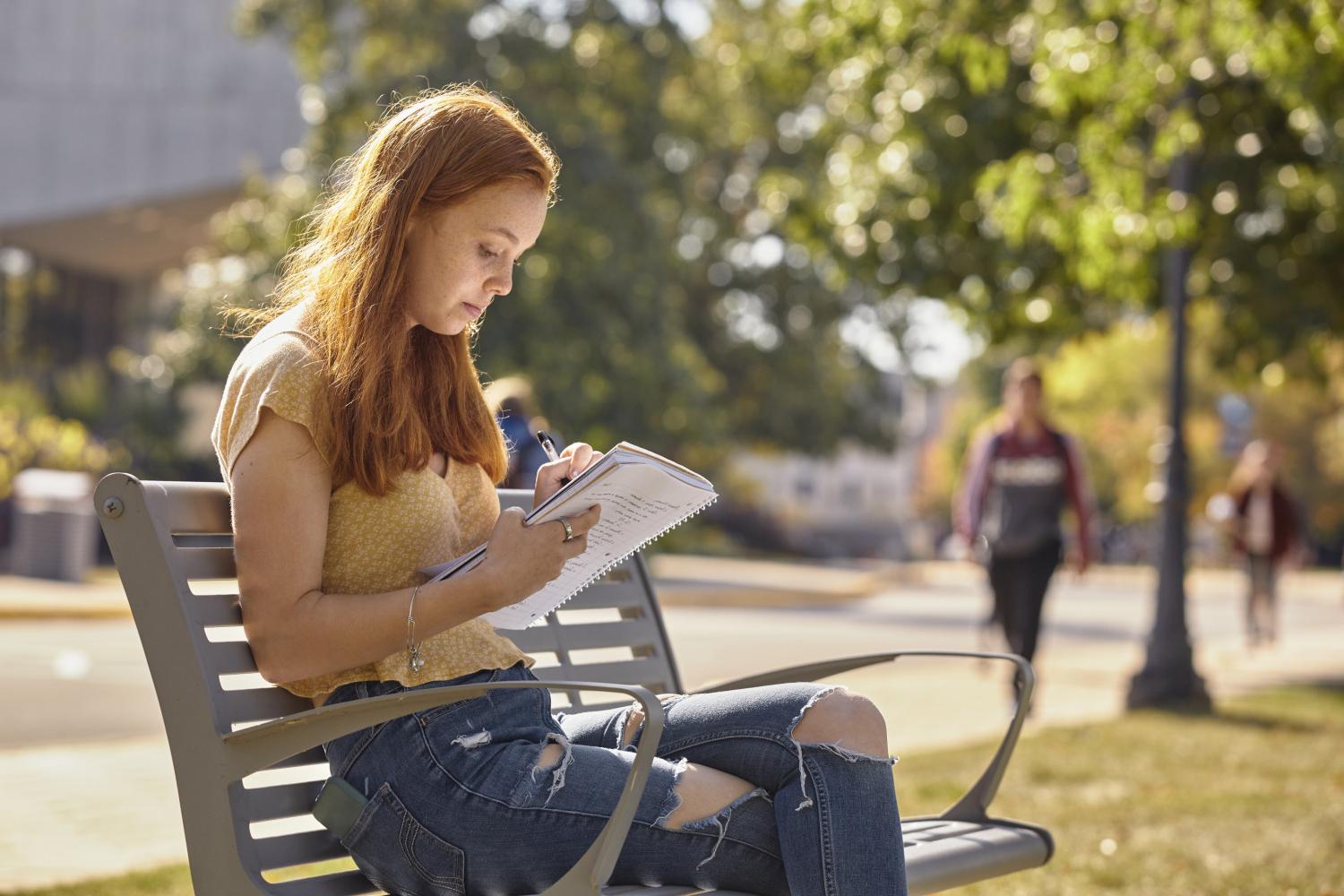 一位<a href='http://ezng.thechromaticendpin.com/'>全球十大赌钱排行app</a>学院的学生在校园里的长椅上读书.